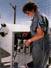 A health physicist removes air sampling filters at an environmental monitoring station